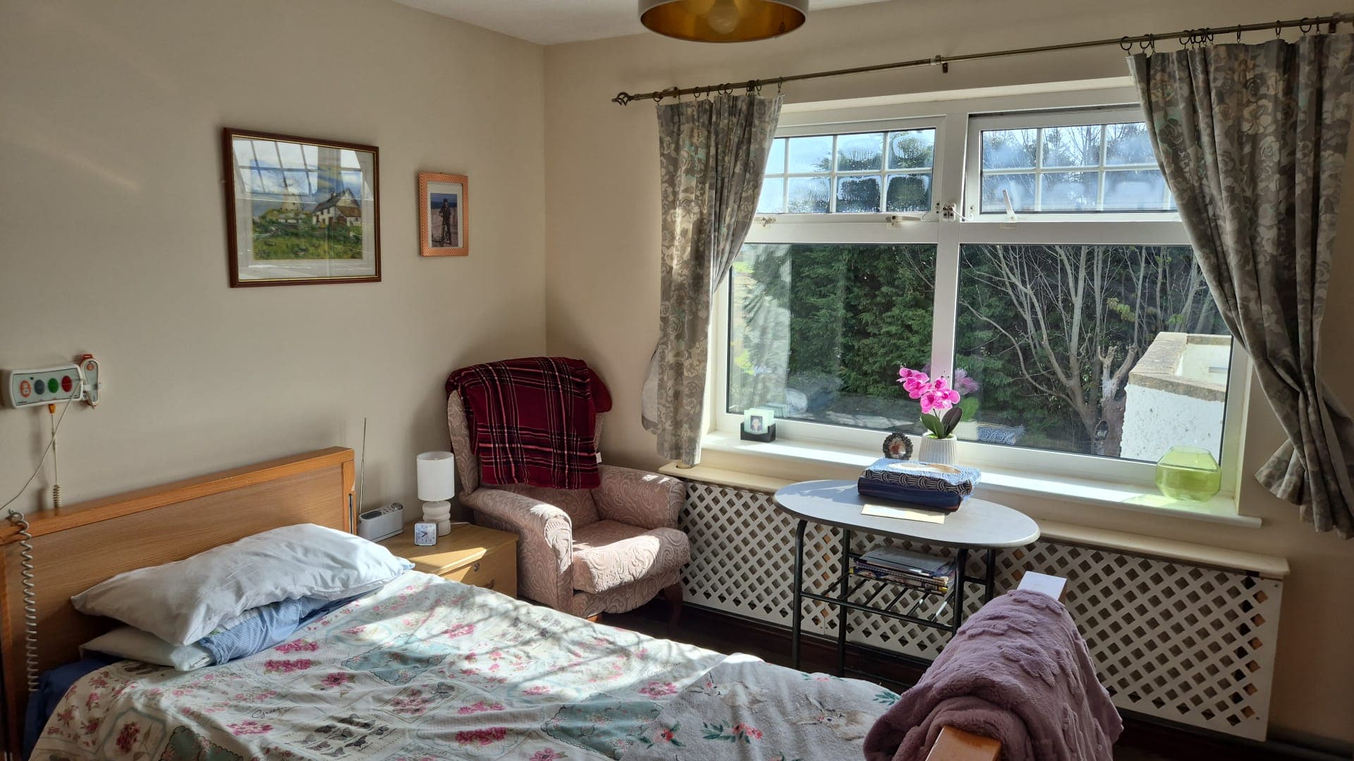 A neatly made bed in a resident room